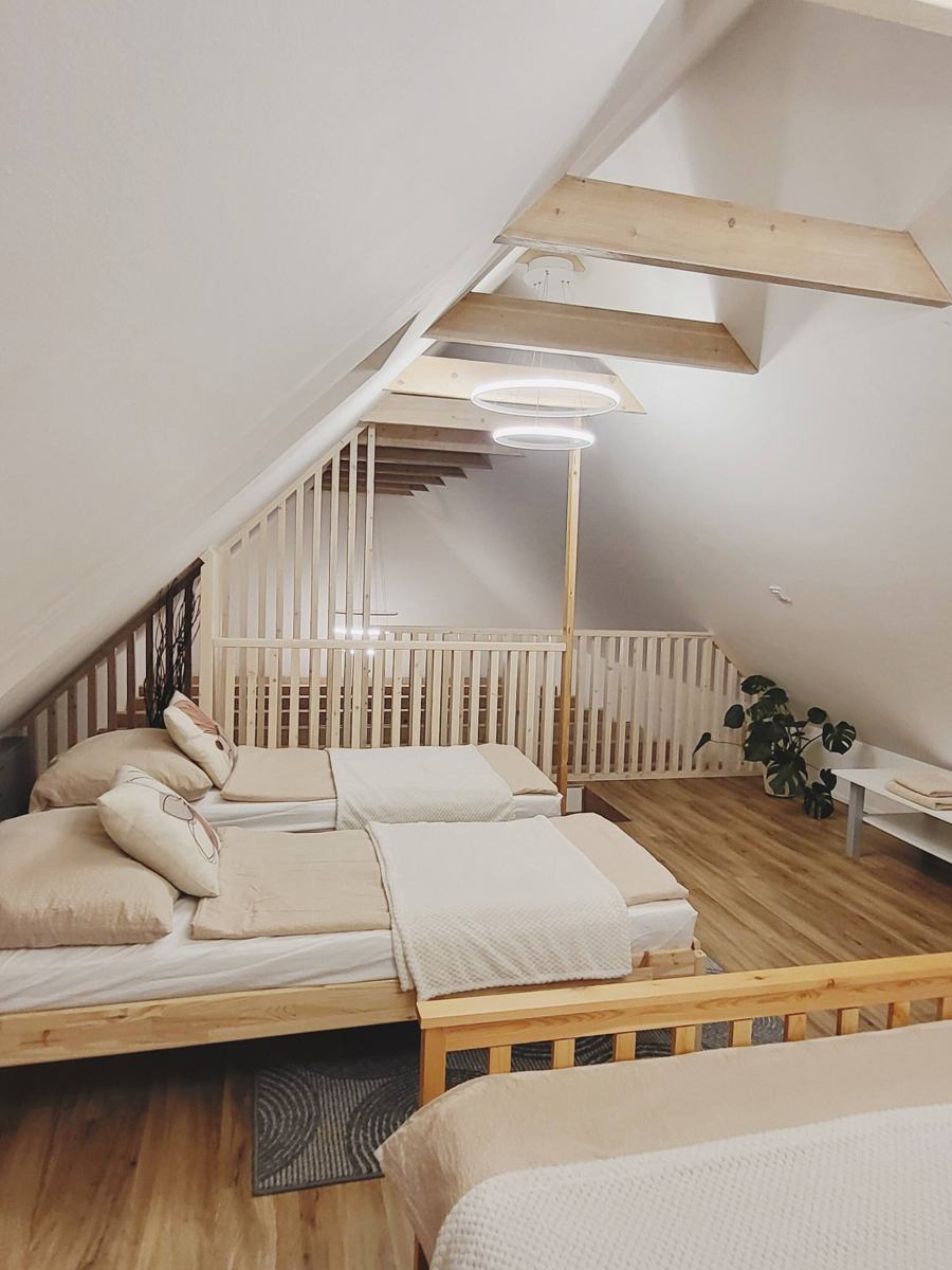 Jednolůžka pod šikmou střechou a dřevěné zábradlí